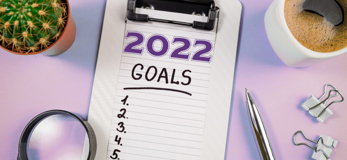 New year goals 2022 on desk. 2022 goals with open notebook, coff